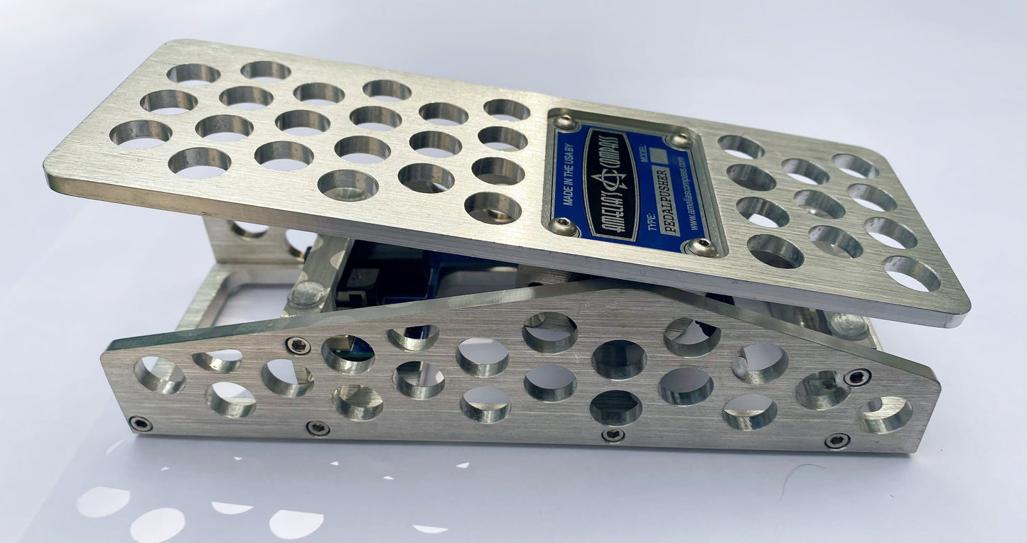 An aluminum PedalPusher expression pedal, featuring multiple holes on the top surface and a blue label in the center.